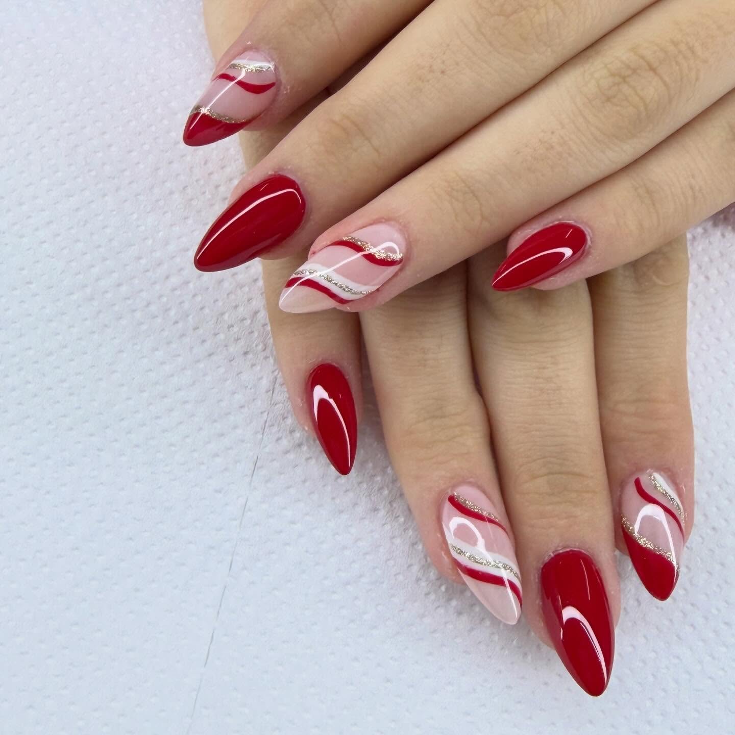 Deep Red Nails with Elegant Swirls and Gold Glitter Accents